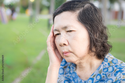 portrait of lonely senior asian woman in garden