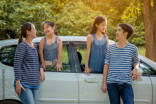 Happy Asian family with mini van are smiling and preparing for travel on summer