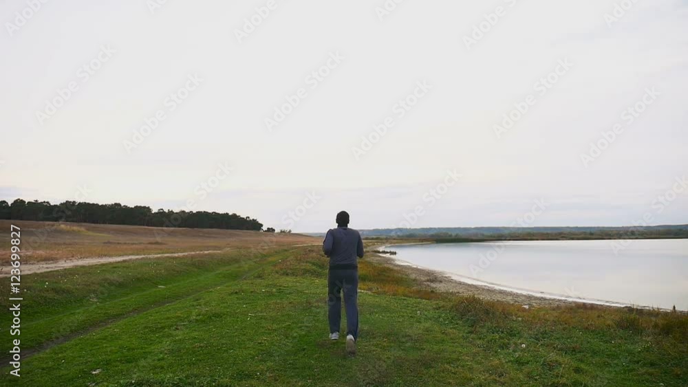 athlete runs runner on man nature near a lake healthy lifestyle athlete runs runner on man nature near a lake healthy lifestyle