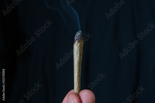 marijuana or cannabis joint smoking isolated against a black background