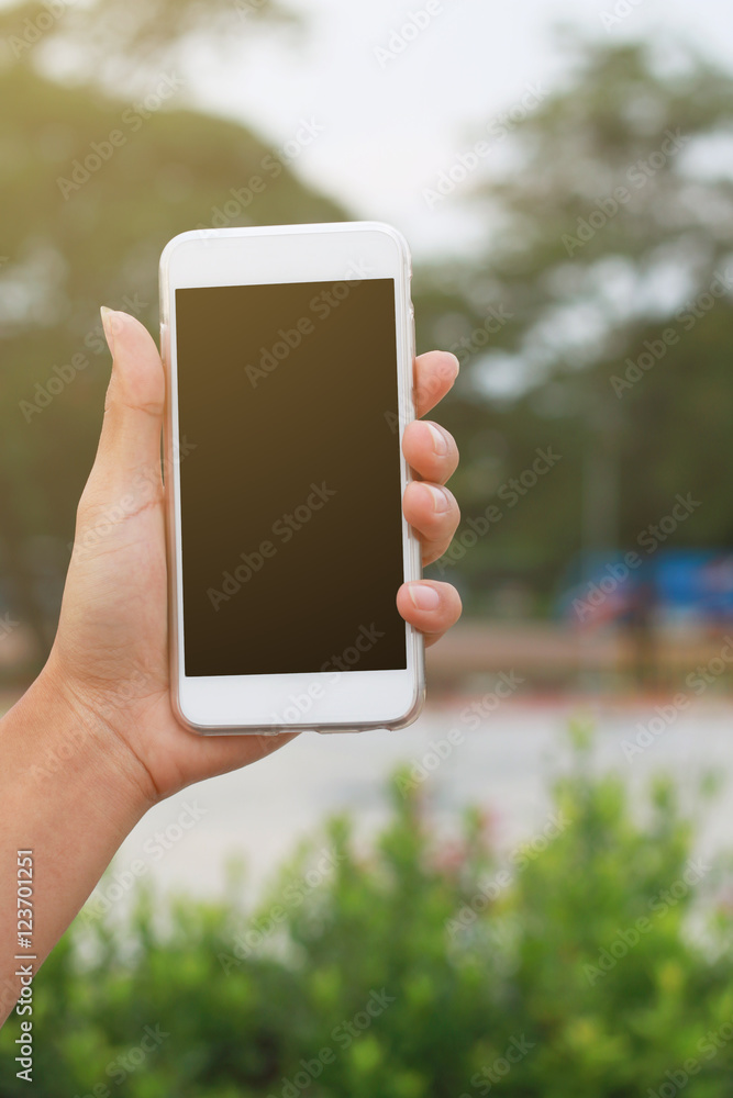 Hand holding phone isolated on black clipping inside