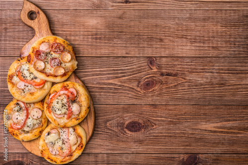 Mini pizzas on wooden board.