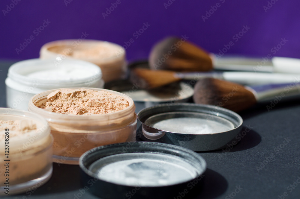 White and beige mineral powder for long lasting make up and a set of make up brushes on background White and beige mineral powder for long lasting make up and a set of make up brushes on background