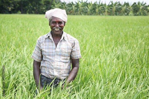 фотографія Indian Man Holding sickle and crops