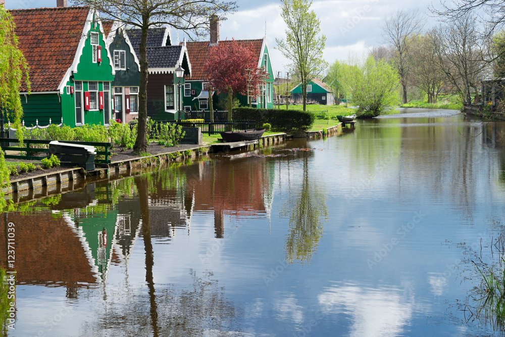rural dutch scenery of small traditional town Zaanse Schan with reflections in canal, Netherlands