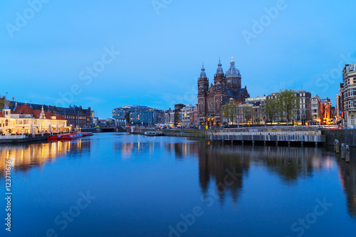 Amsterdam skyline with Church of St Nicholas over old town canal at night, Amsterdam, Holland