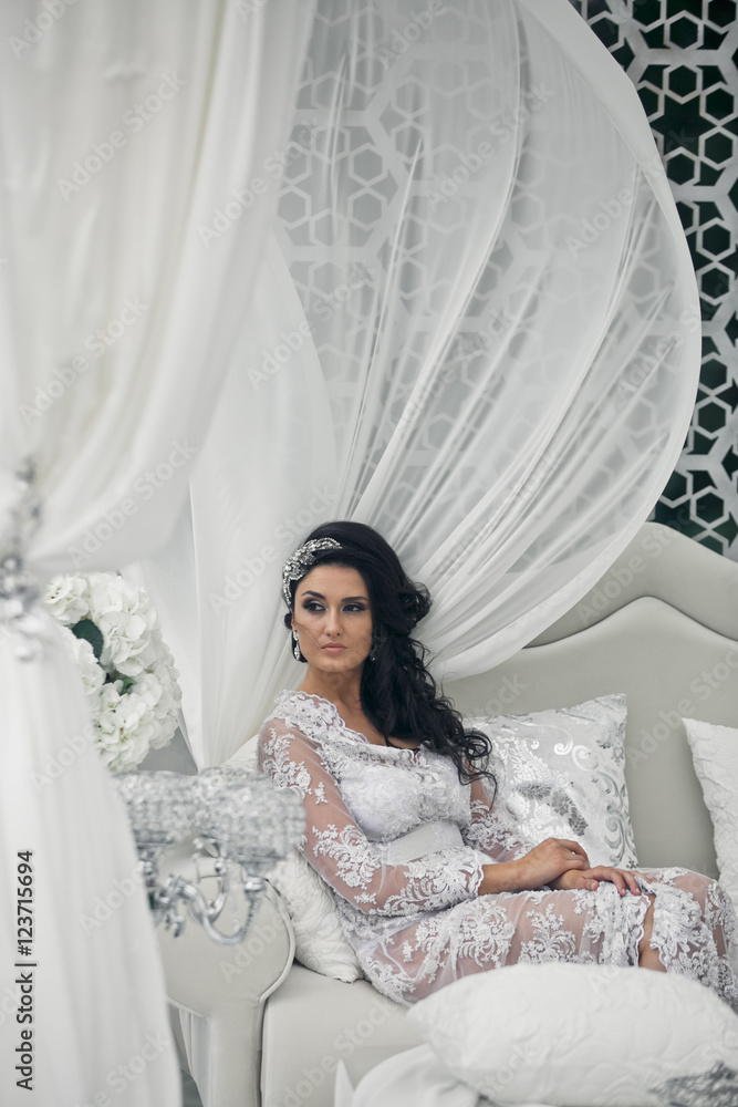 Fototapeta premium The charming bride sits on the luxury sofa