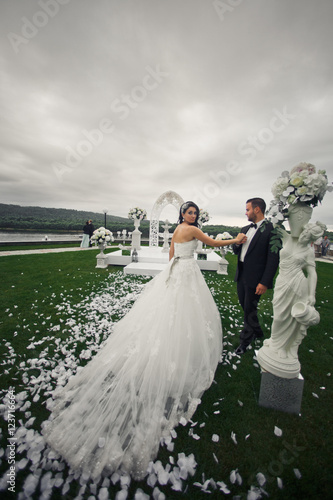 The lovely couple in love hold hands  near statuette