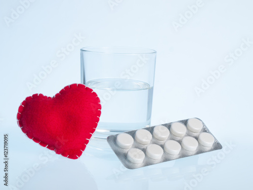 Heart, glass of water and pills