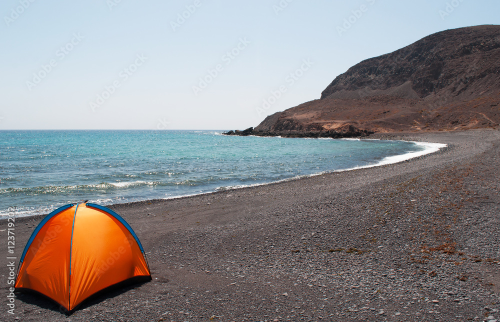 Fuerteventura, Isole Canarie: una tenda arancione sulla spiaggia nera di Pozo Negro, piccolo villaggio di pescatori al centro dell'isola, il 6 settembre 2016