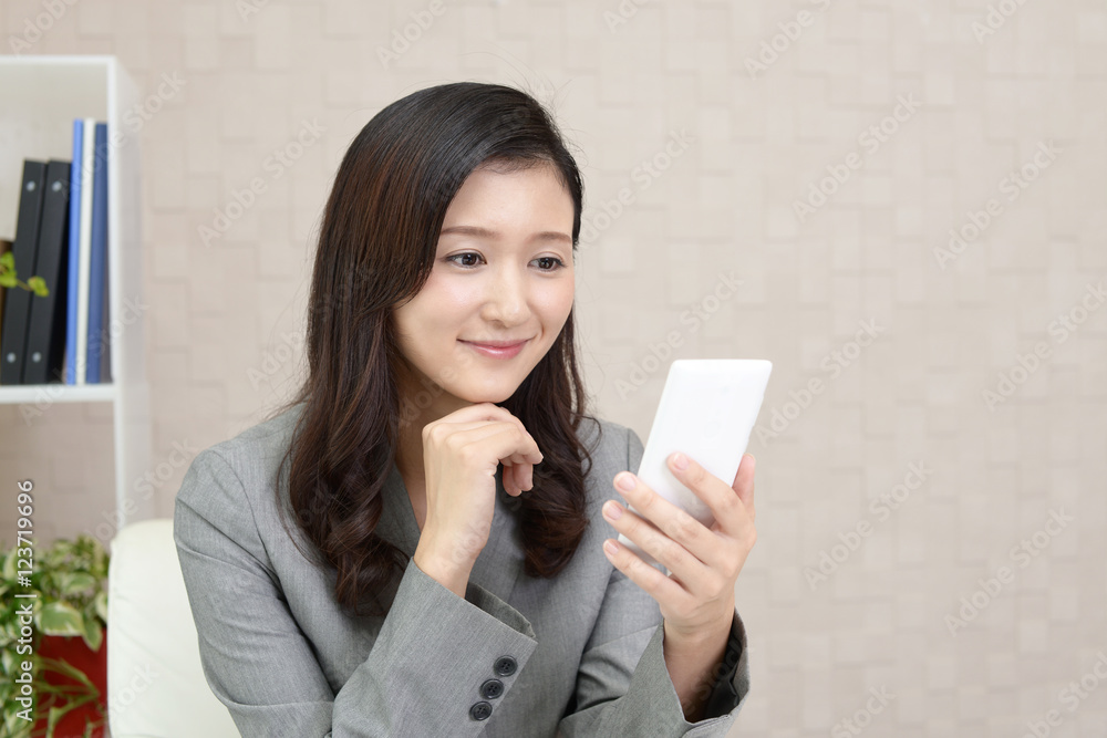 スマートフォンをもつ笑顔のビジネスウーマン スマートフォンをもつ笑顔のビジネスウーマン