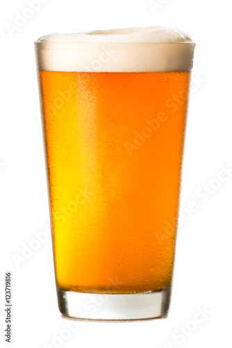 Photo Pint glass of amber ale lager beer with golden light and foamy head isolated on
