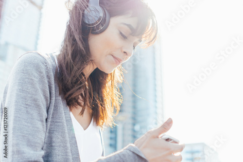 Young Woman Listening Music with Headphones and Mobile Phone  . New York City US photo