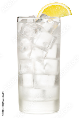 Vodka tonic soda ice water in tall highball glass with lemon wedge garnish isolated on white background