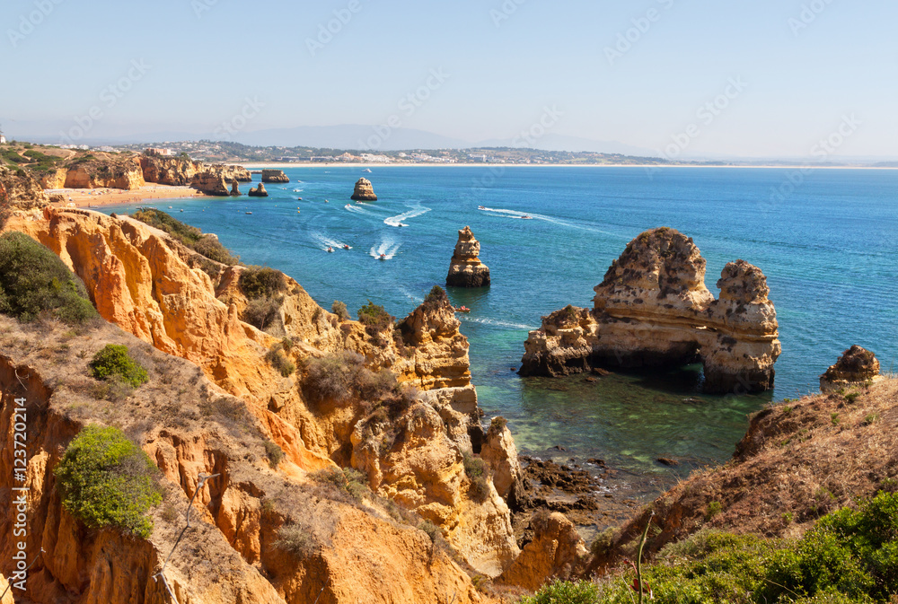 Rock cliff arches on ocean beach and turquoise sea water on coast of Portugal in Algarve region