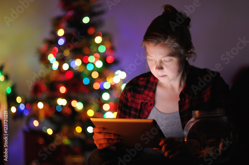 Woman on Christmas eve, using the tablet.