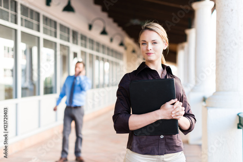 Pretty Young Office Worker with Notebook Outside Offices