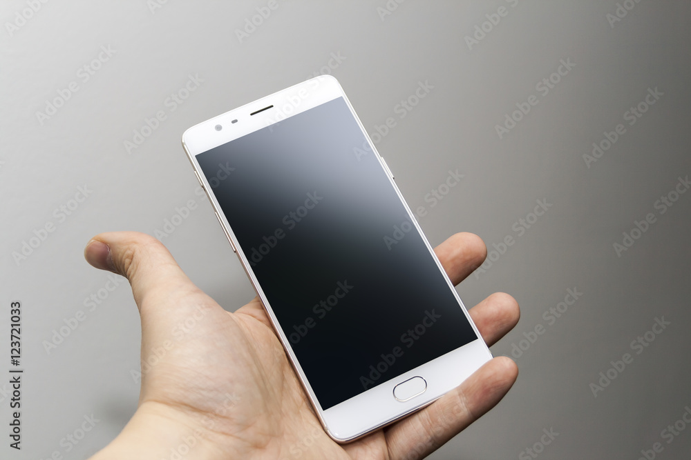 A white smartphone held in hand A white smartphone held in hand