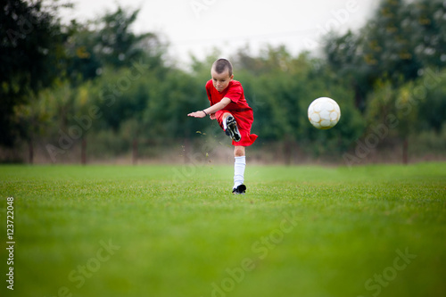 Little football player shooting the ball © marritch
