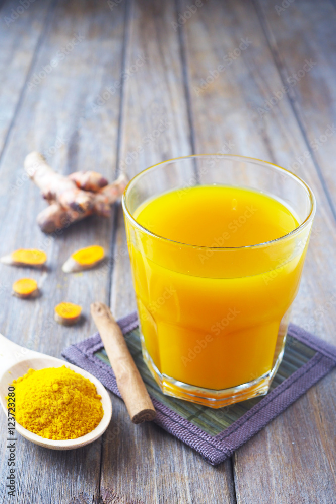 Close up of immunity-boosting spicy turmeric power and tea on a wooden table. Close up of immunity-boosting spicy turmeric power and tea on a wooden table.
