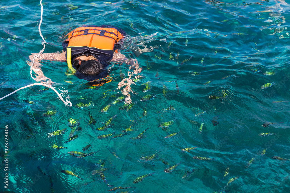 woman snorkeling with life jackets in andaman sea at phi phi islands, Thailand
