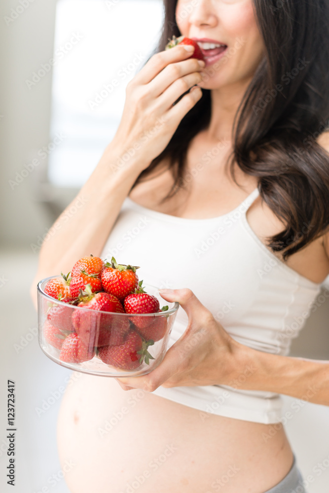 Pregnant Woman Eating Strawberries in home Pregnant Woman Eating Strawberries in home
