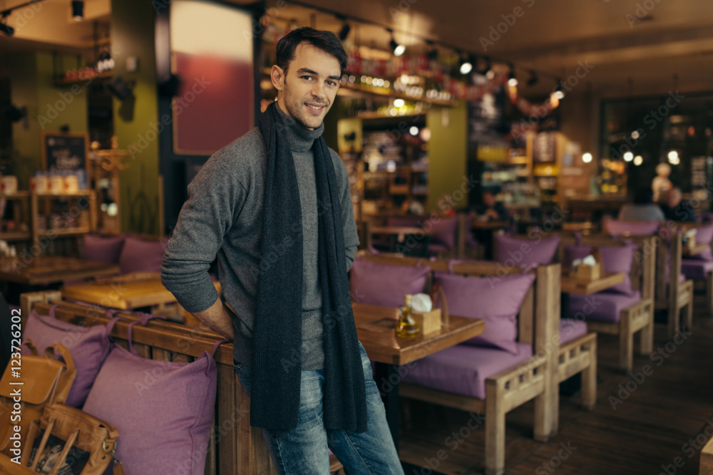 Young handsome man standing and posing in the restaurant Young handsome man standing and posing in the restaurant