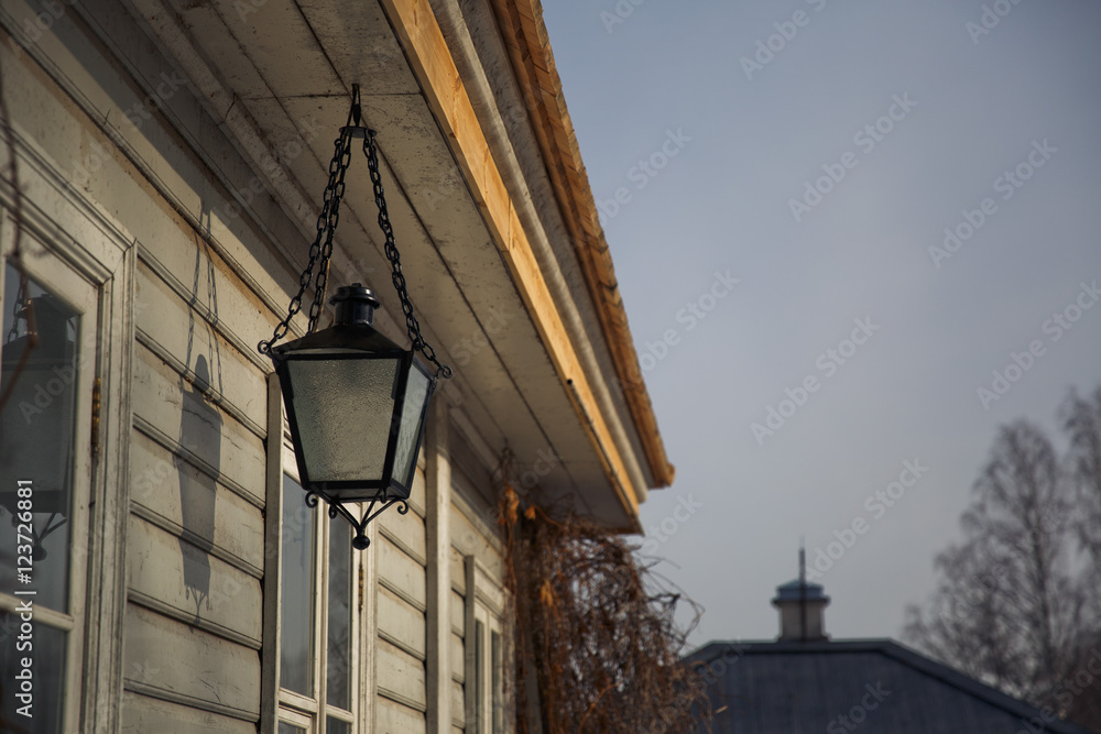 Black steel lantern hangs under an old wooden ceiling