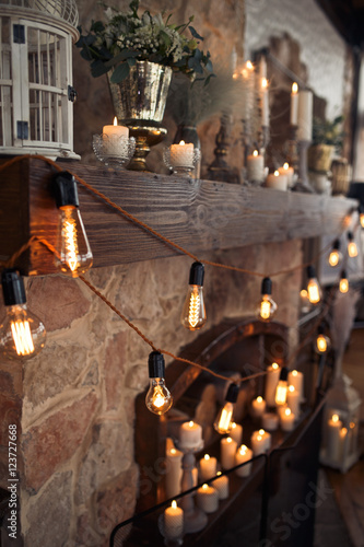 Ropes with electric bulbs decorate an old stone fireplace