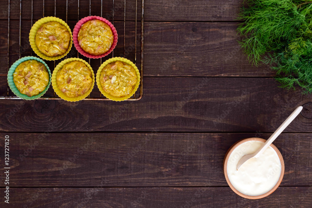 Muffins from cabbage with ham and cheese. Sour cream sauce. The top view Muffins from cabbage with ham and cheese. Sour cream sauce. The top view