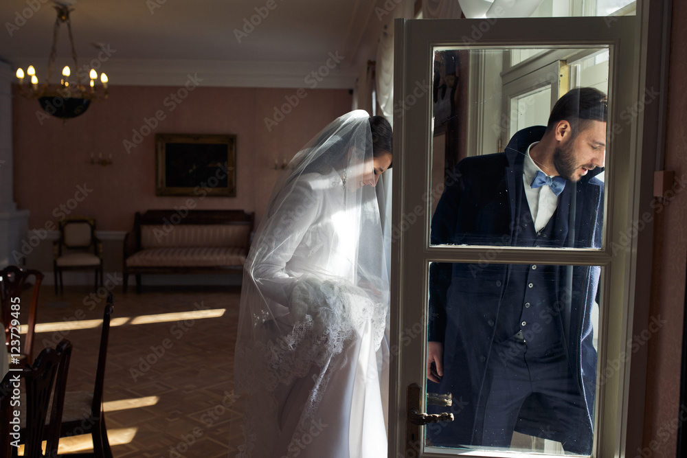Beautiful newlyweds in winter coats walk out of the old-fashione Beautiful newlyweds in winter coats walk out of the old-fashione