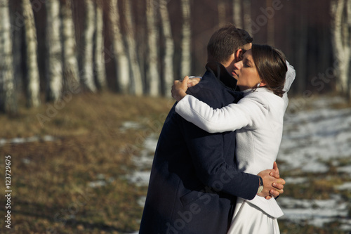 Tender hugs between stylish newlyweds standing outside in the br
