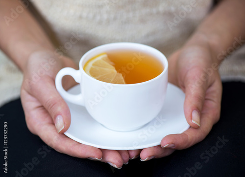 cup of tea with lemon in two hands