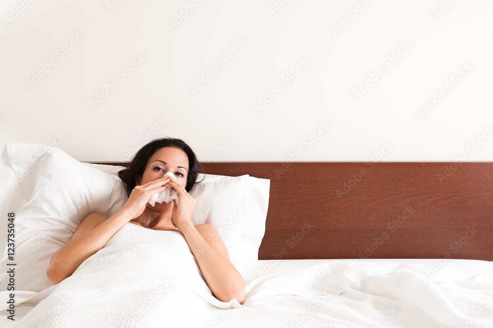 Sick Woman Blowing Nose in Bed Sick Woman Blowing Nose in Bed