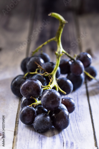 grappolo d'uva nera disposta su base di legno blu. Macro fotografia