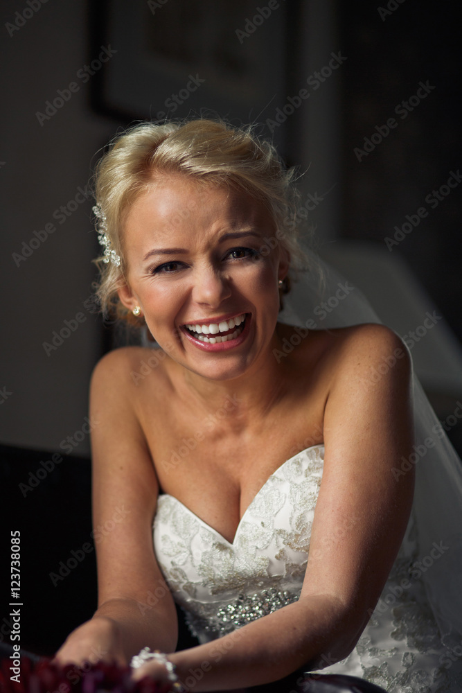 Fototapeta premium Sincere laugh of the blonde bride in the wedding dress
