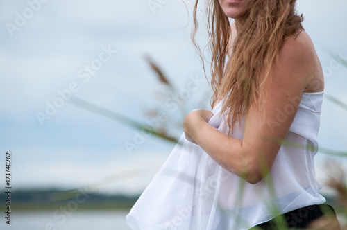 Чувственная девушка с белым шарфом на берегу озера