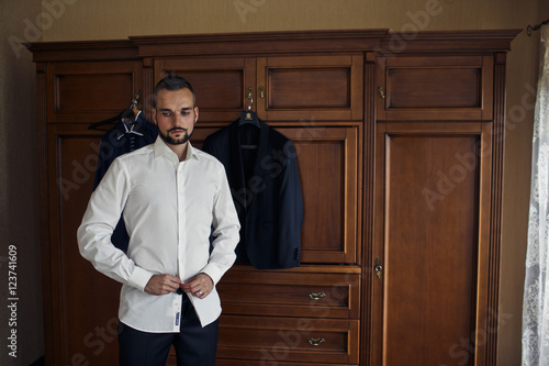 The handsome groom wears a shirt