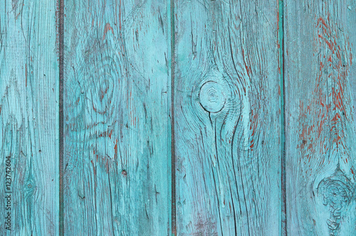 Wooden vertical planks with turquoise paint, old fence