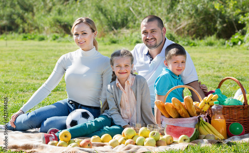 Smiling family of four having a picnic outdoors