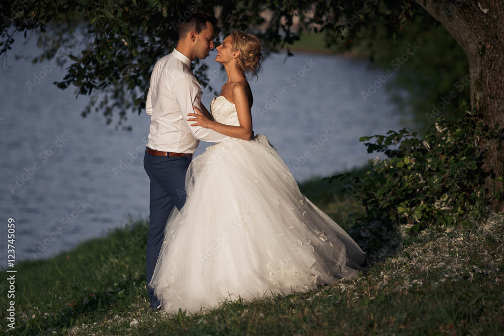 groom higging  his woman at the lake