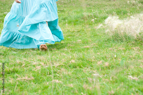 Девушка в голубом длинном платье босиком на зеленой траве © anch87189