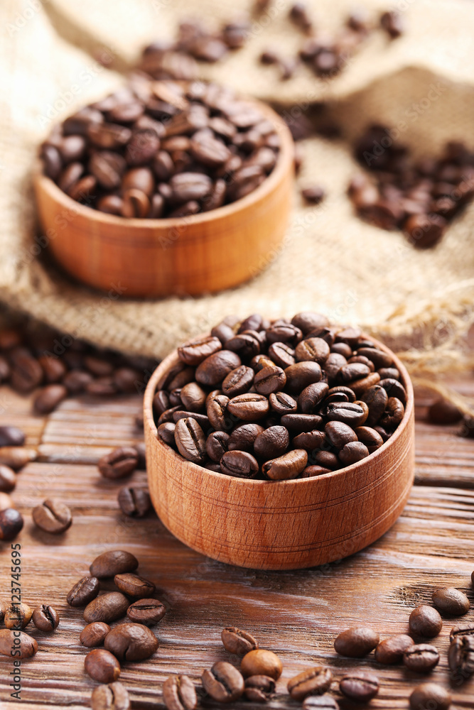 Roasted coffee beans on a brown wooden table Roasted coffee beans on a brown wooden table