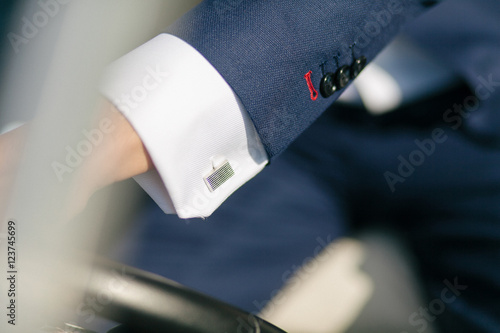Φωτογραφία Silver cufflink on the white shirt of the groom