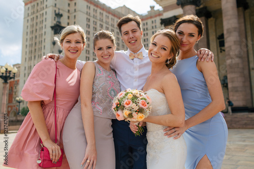 Happy newlyweds with the friends in the downtown