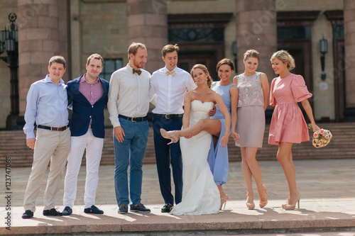 Fototapeta Naklejka Na Ścianę i Meble -  Cheerful newlyweds in the downtown in the wedding day