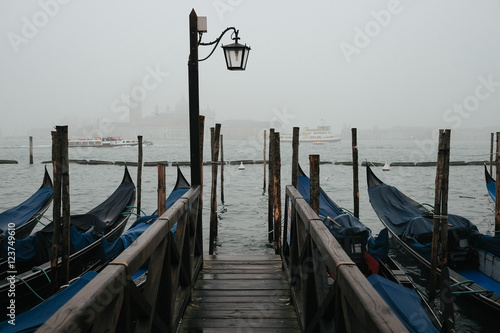 Lonely lantern hangs over a bridge which leads to gondolas
