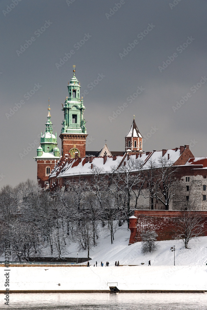 Fototapeta Wawel Castle, Cathedral towers and Vistula River in Krakow, Poland in a cloudy day in winter in last sunlight before the snowfall