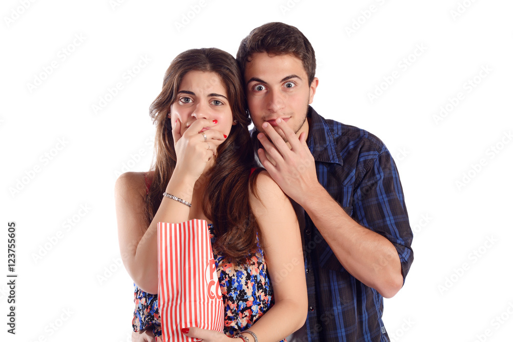 Obraz premium Young couple watching a scary movie and eating popcorn.