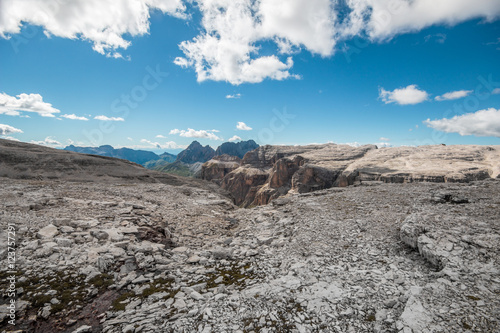 Mountain View over a glacier creek to a cliff of the Sasso Pordoi plateau to the Sassolungo peak in the Dolomites.